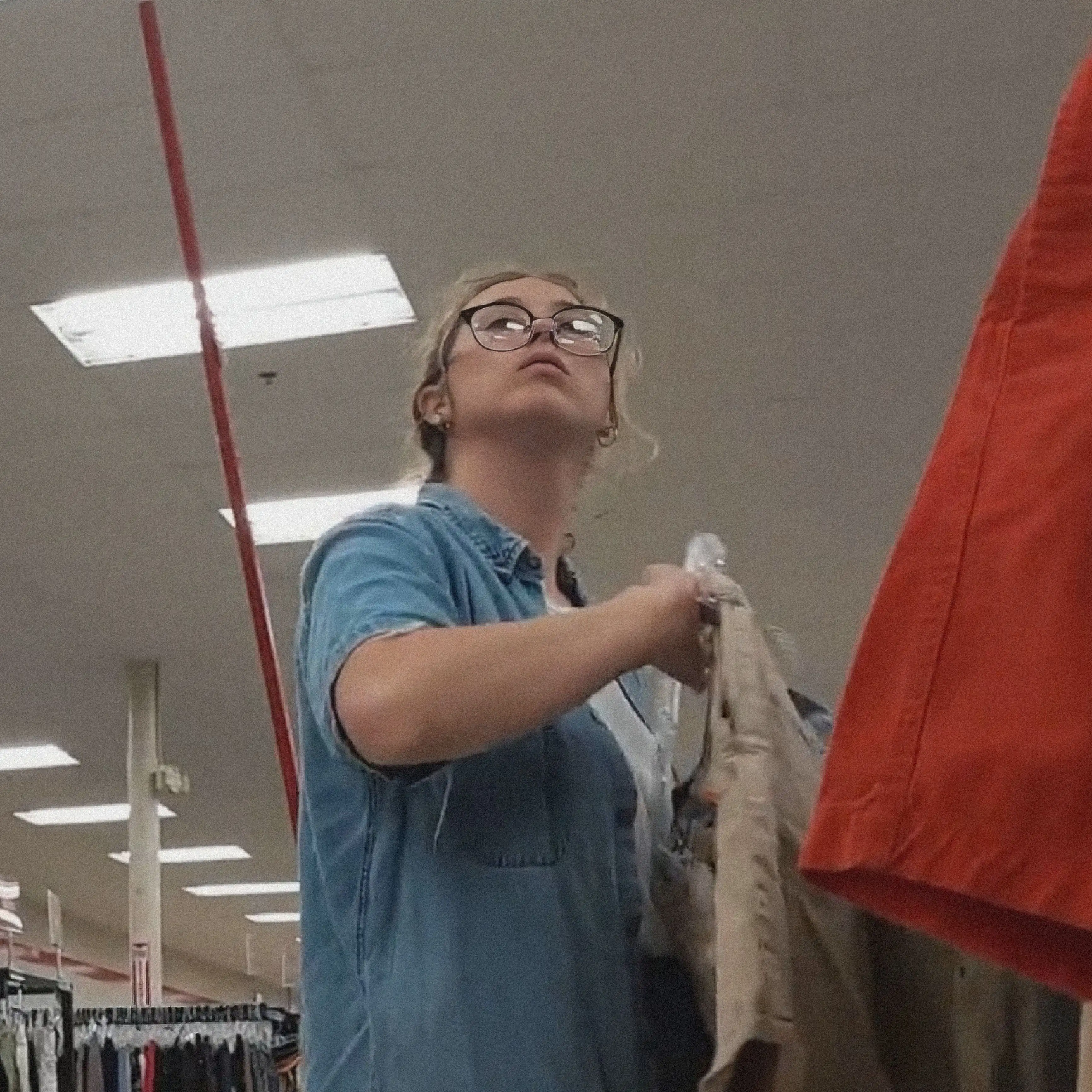 Teen nerd checking out clothes in the store