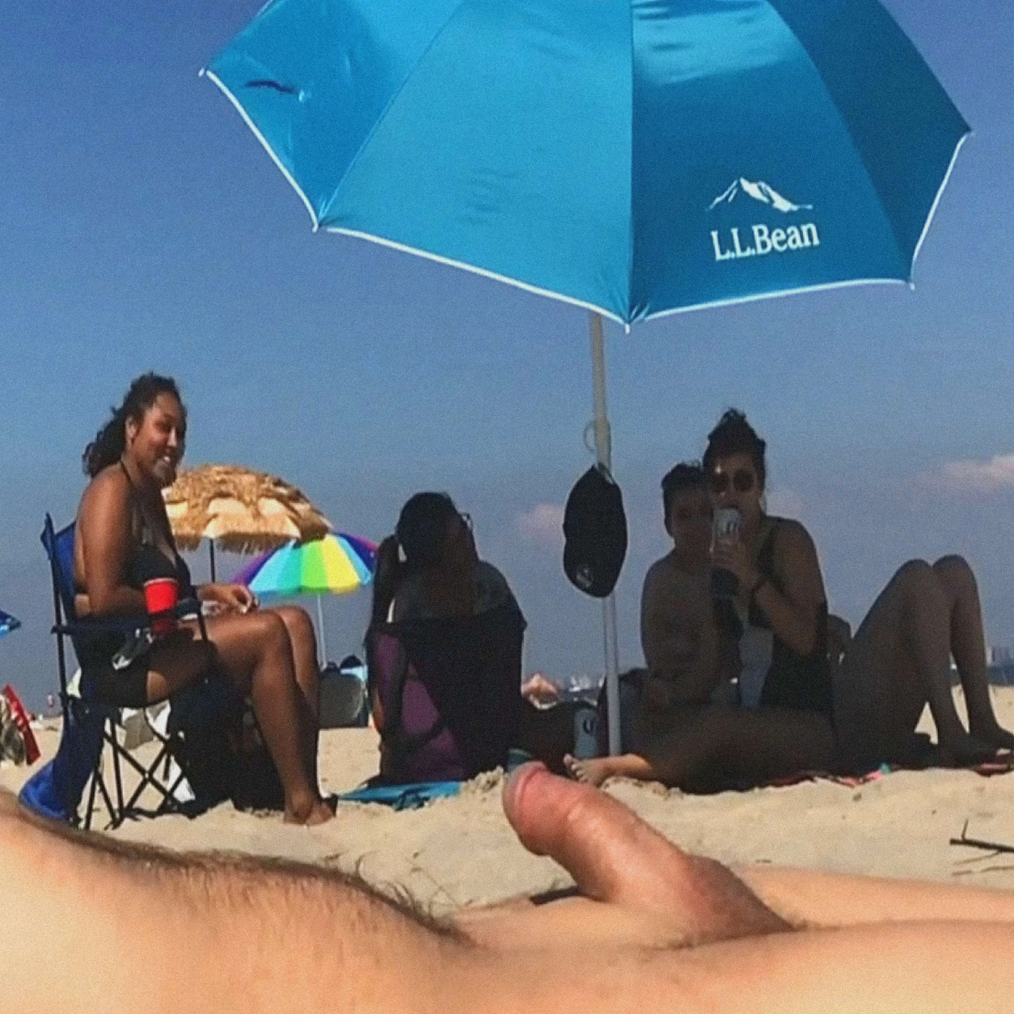 Friends looking at dick on the nude beach.