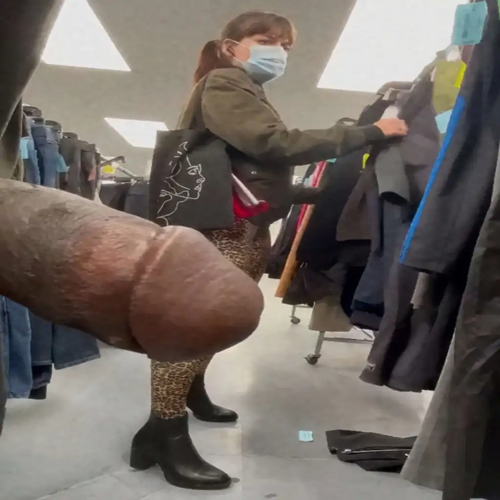 Sexy milf in feline pants looking at clothes in store