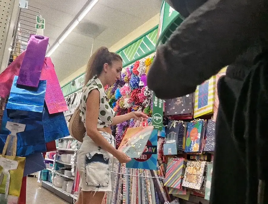 Hot curly girl looking at the products in the store