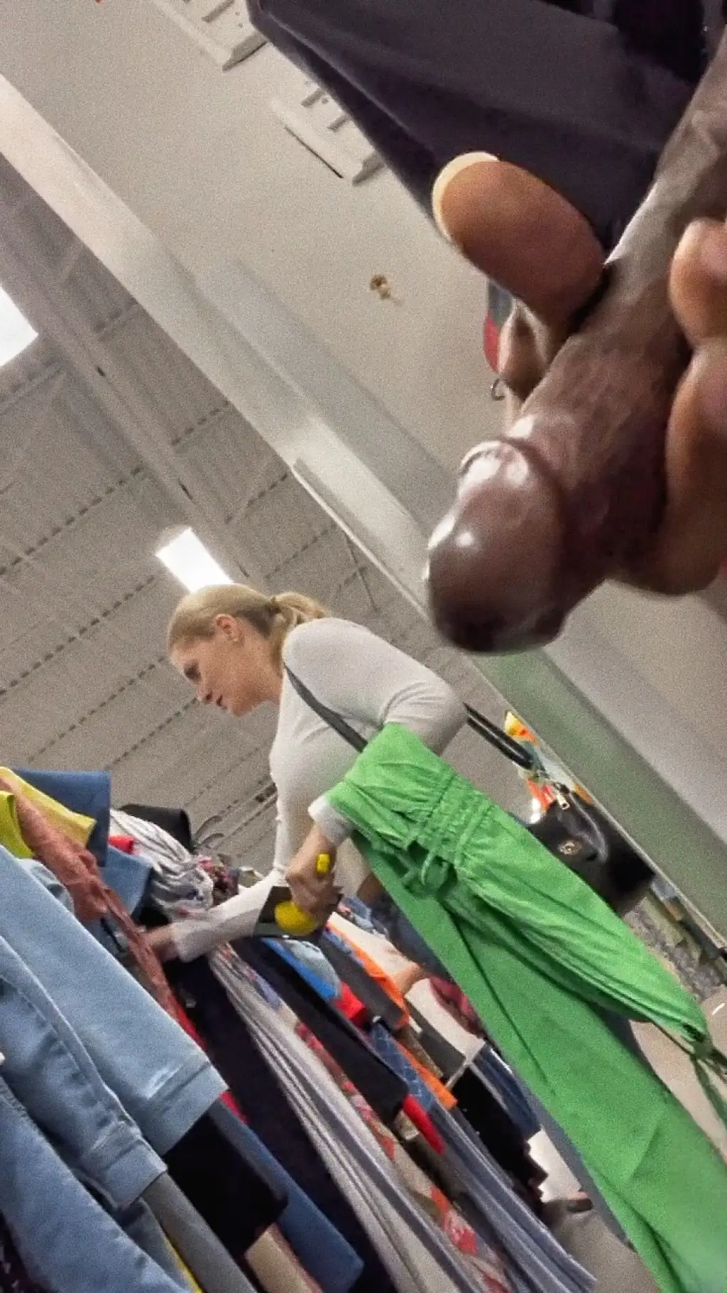 Hot blonde looking at clothes in the store