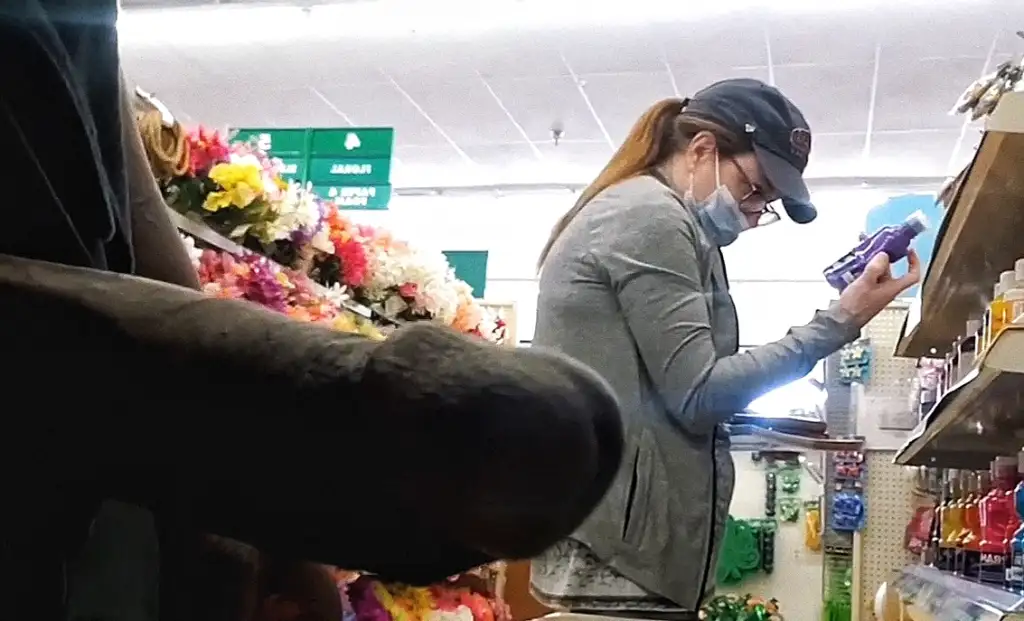 Milf with glasses looking at products in the store