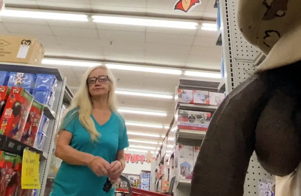 Mature blonde looking at a huge black cock in the store