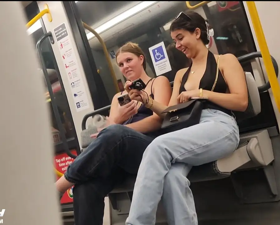 Smiling friends looking at a bulge on the train and taking a picture