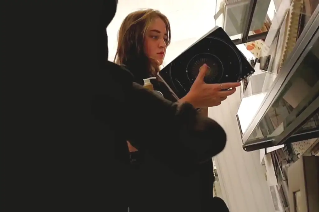 A pretty girl looking at books in the store