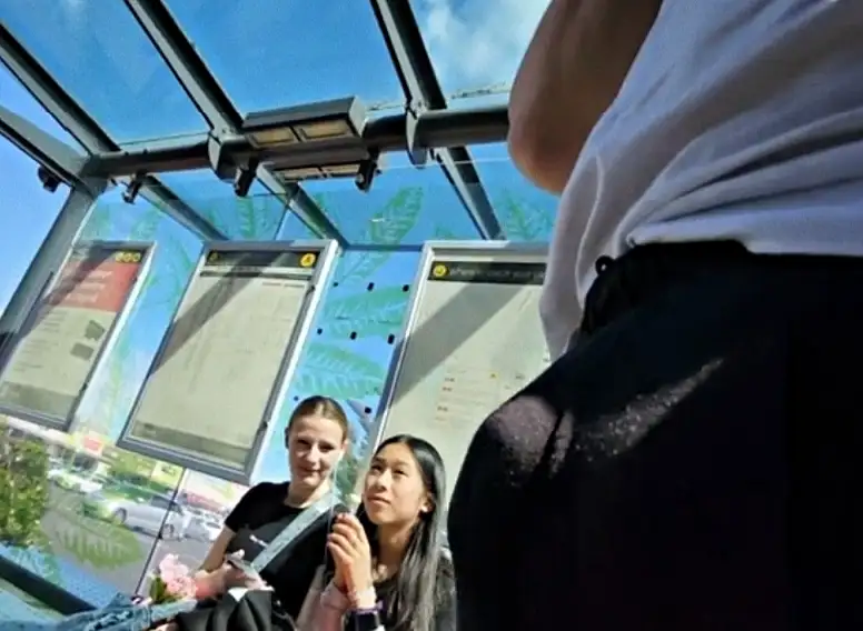 Two hot teens looking at bulge at the bus stop