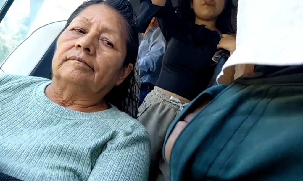 Mature Latina looking at a cock emerging from pants.