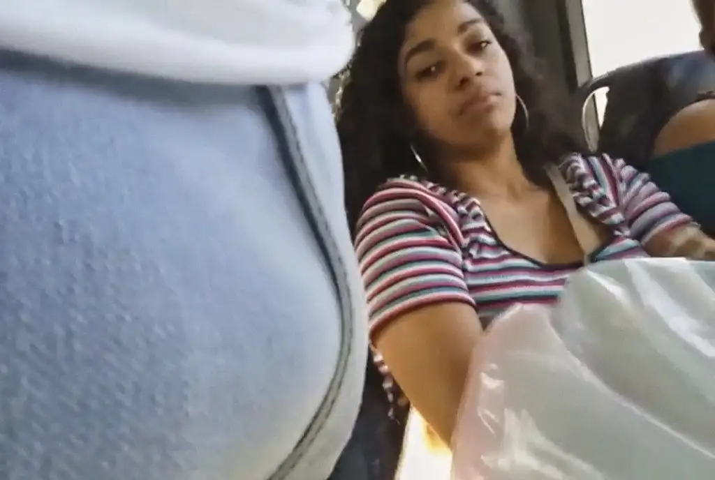 Brazilian brunette looking at a bulge on the bus