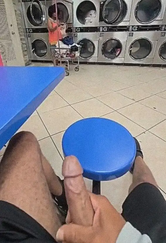 Mature Latina washing clothes in the laundry room