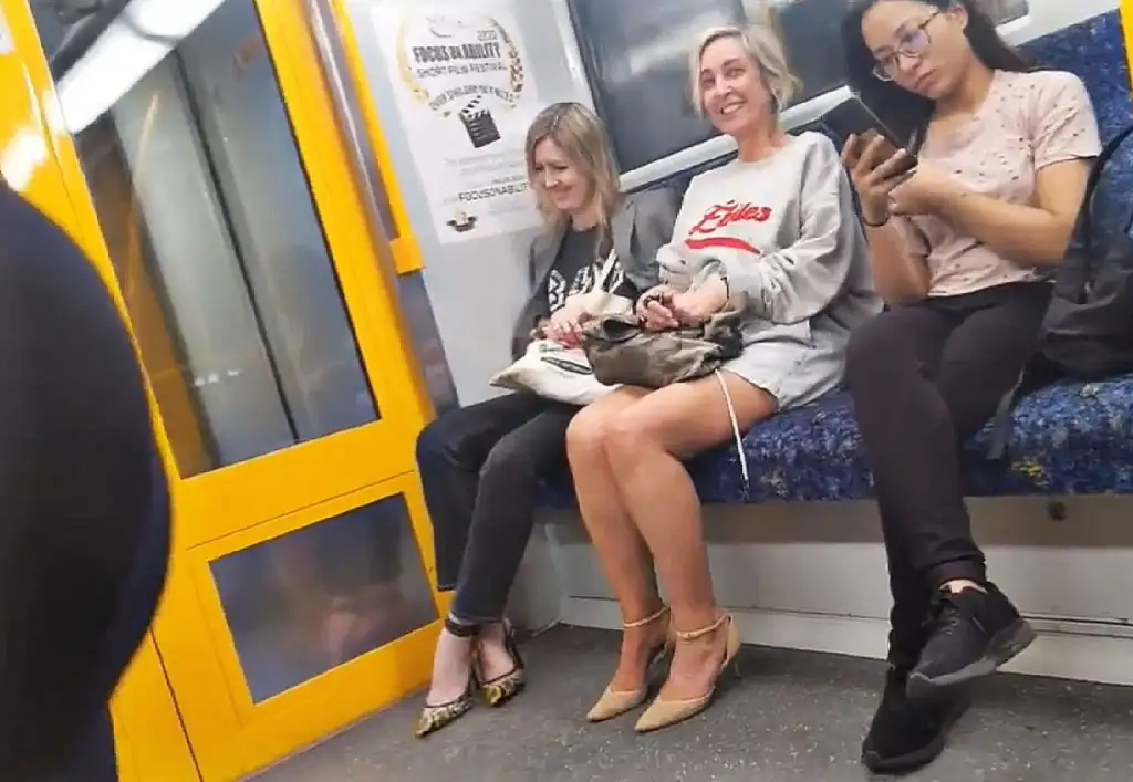 Two sexy MILFs looking at bulge and smiling